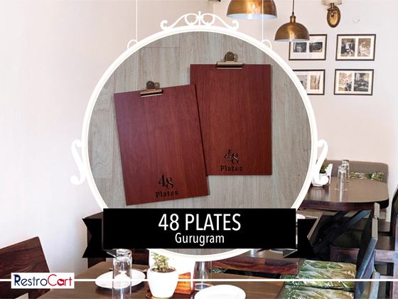 Two wood-finish menu clipboards with metal clips and engraved logo, laid flat, custom made for 48 Plates by RestroCart, New Delhi
