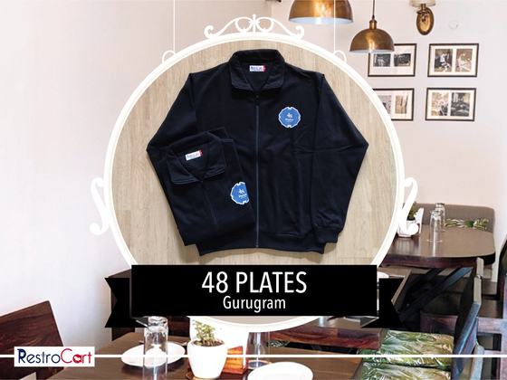 Black zip-up jacket with high collar and round blue logo patch, with a second folded jacket, custom made for 48 Plates by RestroCart, New Delhi