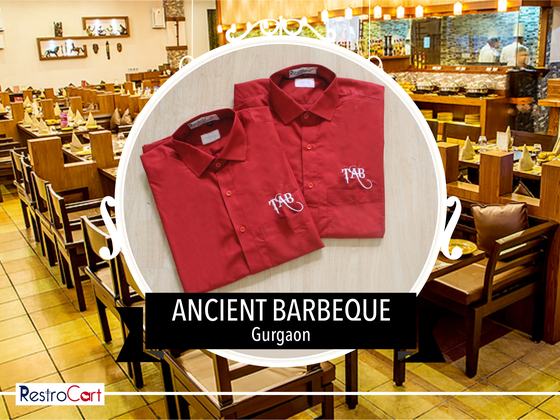 Two red collared uniform shirts with white embroidered initials logo, folded, custom made for Ancient Barbeque by RestroCart, New Delhi
