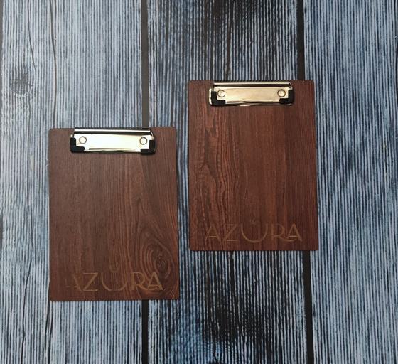 Dark walnut MDF clipboards with steel clips and laser engraved logo, pair on grey wood, custom made for Azura by RestroCart, New Delhi