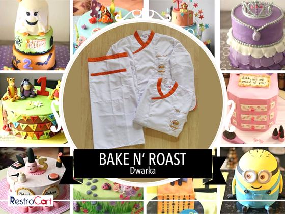 White chef coat with orange collar trim and white half apron with orange stripe, laid flat, custom made for Bake N Roast by RestroCart, New Delhi