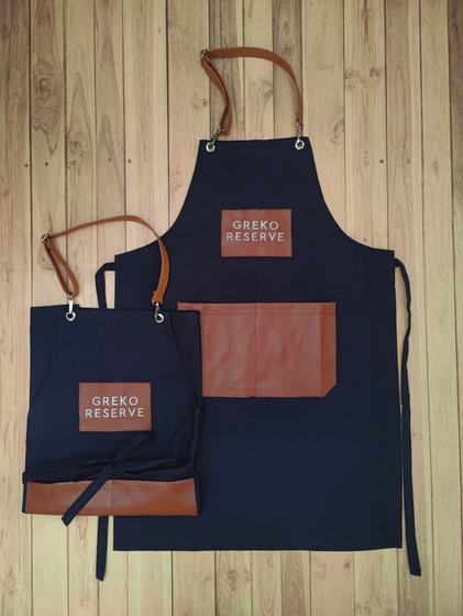 Navy canvas apron pair with tan leatherette pocket panels, straps and white logo patch, custom made by RestroCart, New Delhi