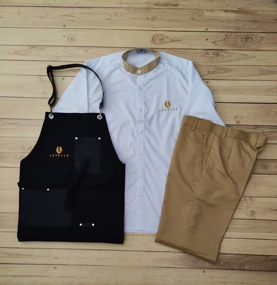 White mandarin collar shirt with khaki collar, black denim bib apron with gold logo and khaki trousers, custom made by RestroCart, New Delhi