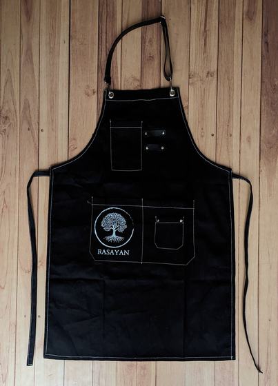 Black canvas bib apron with white contrast stitching, pen pockets and tree logo print, custom made by RestroCart, New Delhi