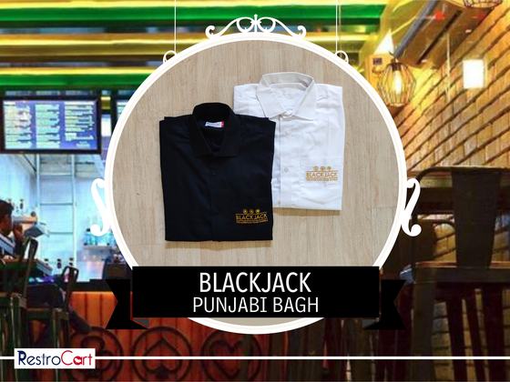 Black and white collared uniform shirts with gold embroidered logo, folded, custom made for Blackjack by RestroCart, New Delhi