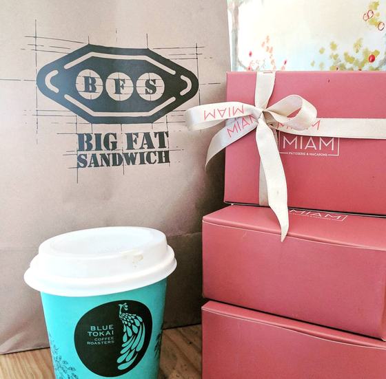 Teal printed paper coffee cup with kraft carry bag and pink gift boxes, custom made for Blue Tokai Coffee Roasters by RestroCart, New Delhi