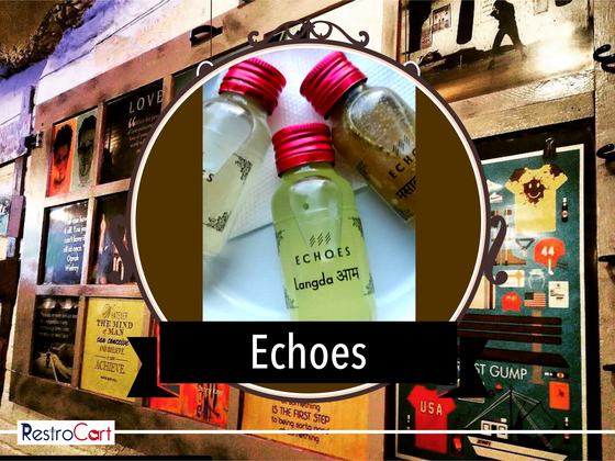 Three small clear glass bottles with red caps and printed logo labels, close-up, custom made by RestroCart, New Delhi