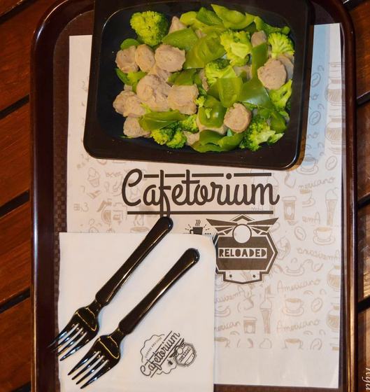 Printed paper tray liner with coffee doodles and logo napkin on a brown tray with a salad bowl, custom made for Cafetorium by RestroCart, New Delhi
