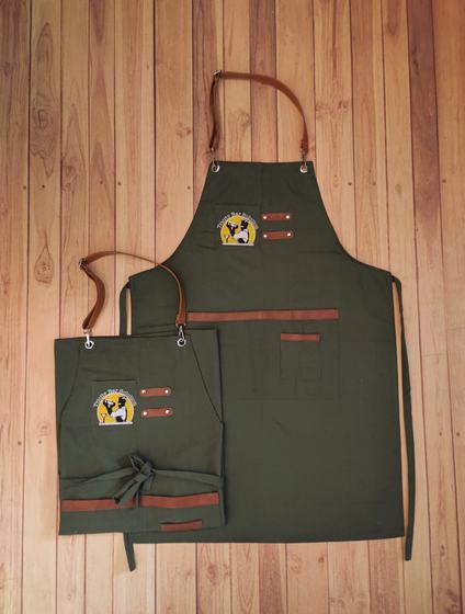 Olive green canvas apron pair with tan leather straps and embroidered round badge logo, custom made by RestroCart, New Delhi