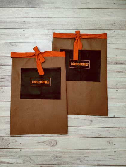 Two brown canvas waist aprons with black pocket panel, orange ties and orange printed logo, custom made by RestroCart, New Delhi