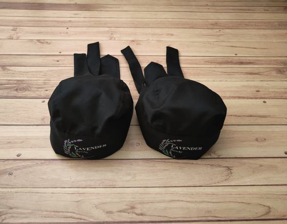 Black chef skull caps with back ties and green printed lavender sprig logo, custom made by RestroCart, New Delhi