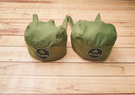 Olive green chef skull caps with back ties and round black and white printed badge, custom made by RestroCart, New Delhi