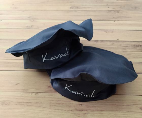 Navy beret style chef caps with white printed script logo, pair on light wood, custom made by RestroCart, New Delhi