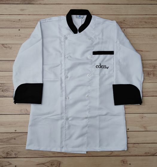 White double breasted chef coat with black collar, black cuffs and black pocket trim, laid flat, custom made by RestroCart, New Delhi