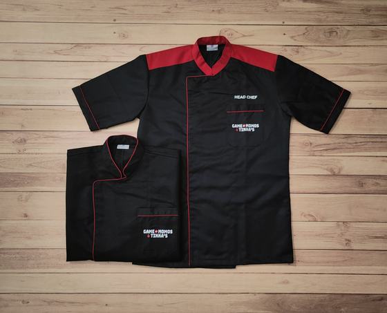 Black short sleeve chef coats with red yoke, red piping and white embroidered chest text, custom made by RestroCart, New Delhi