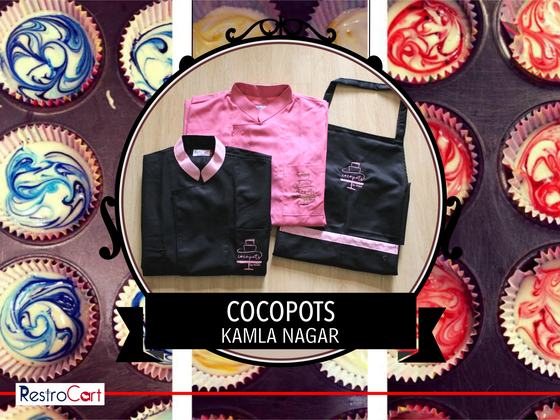Black and pink chef coats with pink collar trim and black bib apron with pink stripe, custom made for Cocopots by RestroCart, New Delhi