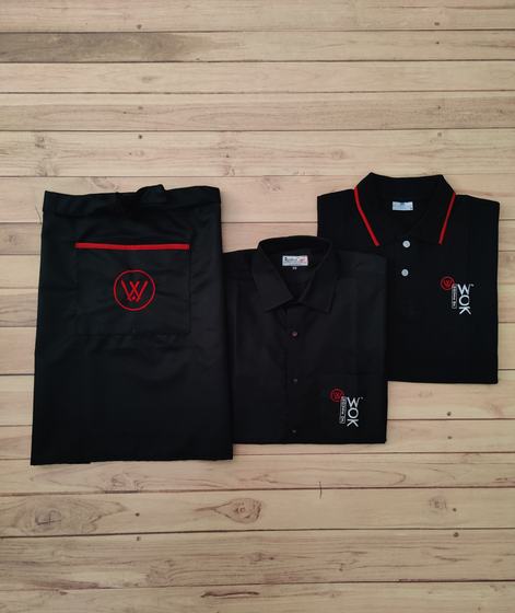 Black waist apron, black shirt and black polo with red collar tipping, all carrying the same red logo, a coordinated restaurant uniform set by RestroCart