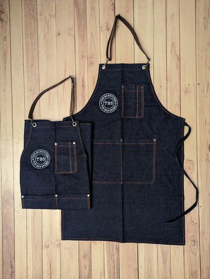 Large and small raw denim bib aprons with orange contrast stitching, rivets and round printed logo, custom made by RestroCart, New Delhi