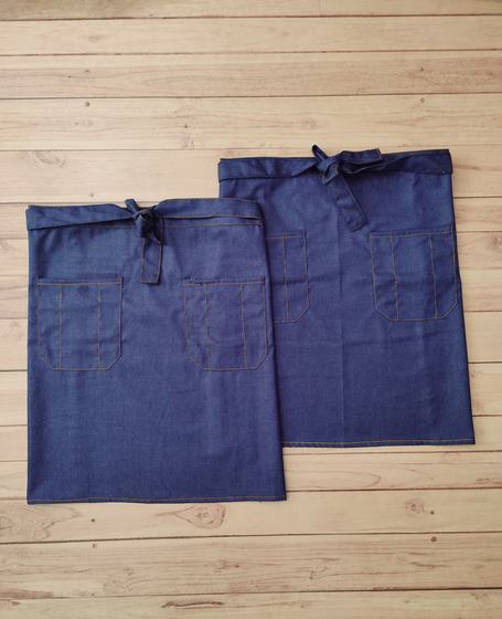 Two blue denim waist aprons with patch pockets and orange contrast stitching, no logo, custom made by RestroCart, New Delhi