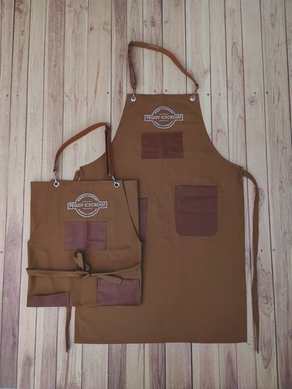 Brown canvas apron pair with leatherette patches, pockets and printed round badge logo, custom made by RestroCart, New Delhi