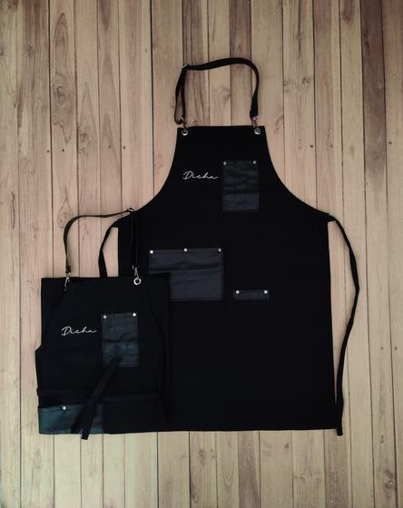 Black canvas apron pair with black leatherette pockets and white script logo, custom made by RestroCart, New Delhi