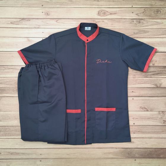 Charcoal housekeeping tunic with coral collar, cuffs and pocket trims and script logo, with trousers, custom made for Dicha by RestroCart, New Delhi