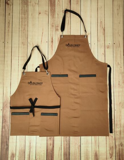 Golden brown canvas apron pair with black straps, black pocket trims and printed logo, custom made by RestroCart, New Delhi