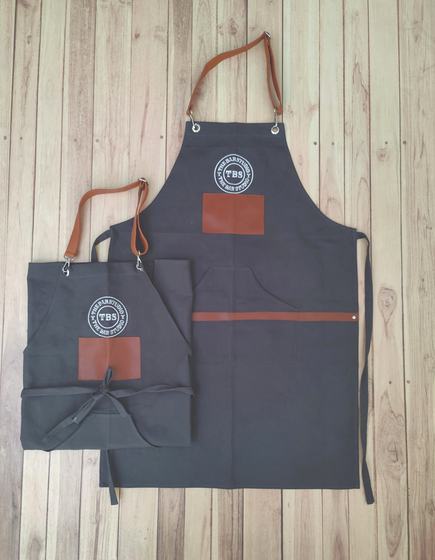 Charcoal canvas apron pair with round white logo print and tan leatherette patches, custom made by RestroCart, New Delhi