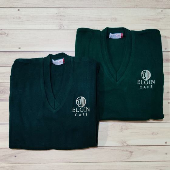 Two bottle green V-neck knit sweaters with white embroidered cafe logo, folded, custom made for Elgin Cafe by RestroCart, New Delhi