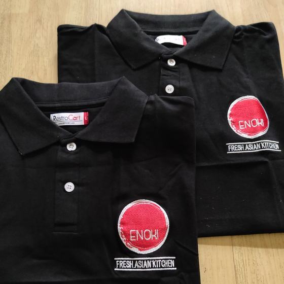 Black polo t-shirts with large round red embroidered logo and tagline, close view, custom made for Enoki Kitchen by RestroCart, New Delhi