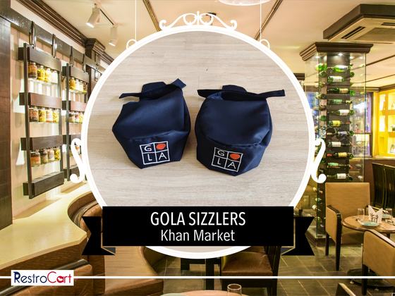 Two navy fabric chef caps with white printed square logo, set on a wooden surface, custom made for Gola Sizzlers by RestroCart, New Delhi