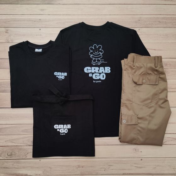 Black t-shirts and waist apron with white printed mascot logo and khaki cargo trousers, custom made for Grab & Go by RestroCart, New Delhi