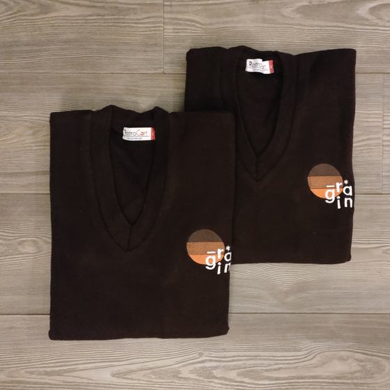 Dark brown V-neck knit sweaters with round colour-block logo, two folded, custom made for Grain by RestroCart, New Delhi