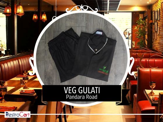 Black housekeeping tunic with white collar trim and green logo and black trousers, custom made for Gulati by RestroCart, New Delhi