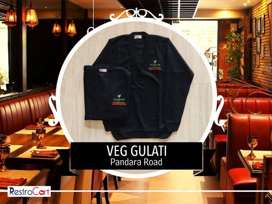 Black knitted cardigans with small green and red embroidered logo, one folded, custom made for Gulati by RestroCart, New Delhi