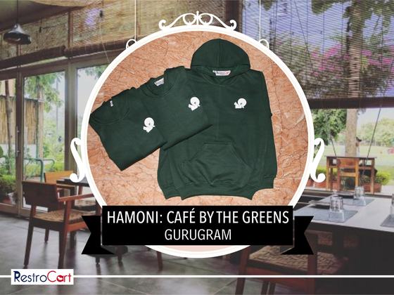 Dark green hoodie and sweatshirt with small white printed logos, laid flat together, custom made for Hamoni Cafe by RestroCart, New Delhi