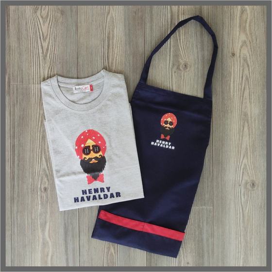 Grey t-shirt with turbaned mascot print and navy bib apron with red hem and logo, custom made for Henry Havaldar by RestroCart, New Delhi