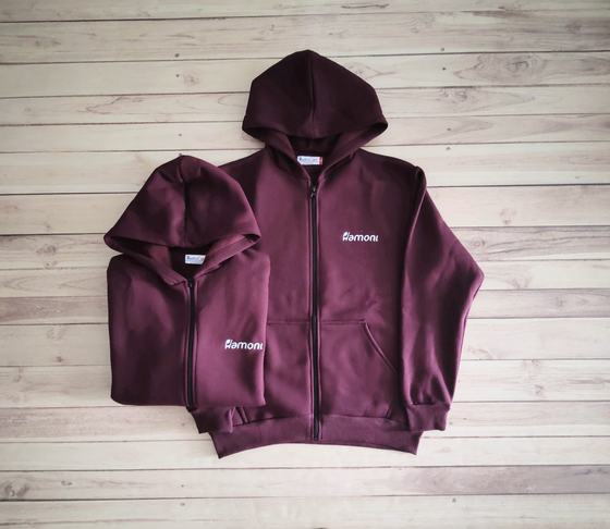 Maroon hooded zip jackets in two sizes with small white printed chest logo, laid flat, custom made by RestroCart, New Delhi
