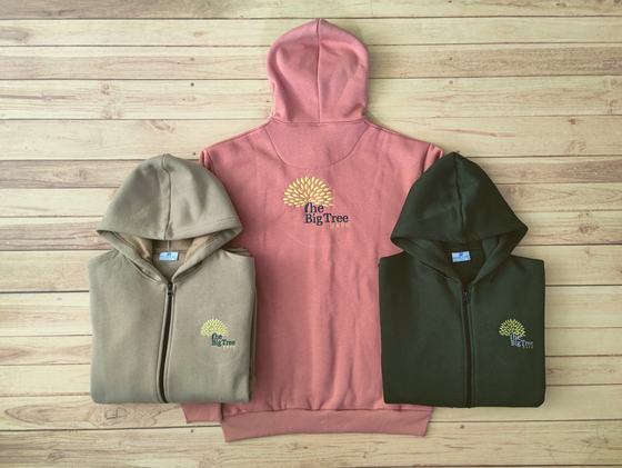 Beige and olive zip hoodies with gold embroidered tree logo beside a dusty pink pullover hoodie, custom made by RestroCart, New Delhi