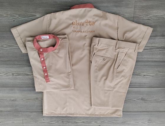 Sand-coloured spa tunic with a coral mandarin collar and placket, with matching trousers, custom spa uniform by RestroCart