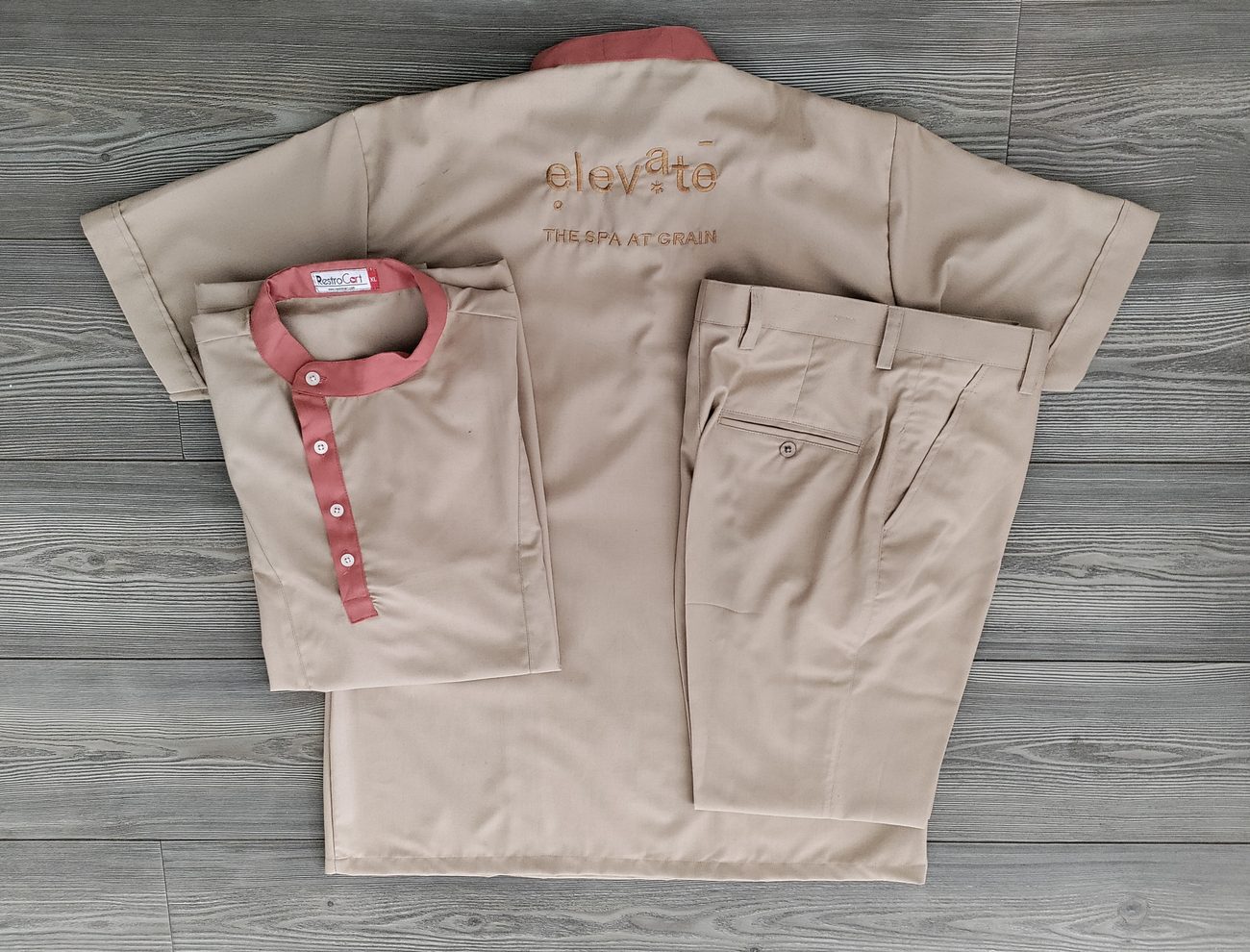 Sand-coloured spa tunic with a coral mandarin collar and placket, with matching trousers, custom spa uniform by RestroCart