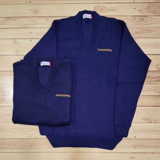Two navy V-neck knit sweaters with gold Housekeeping embroidery on chest, laid flat, custom made for Housewood Villas by RestroCart, New Delhi