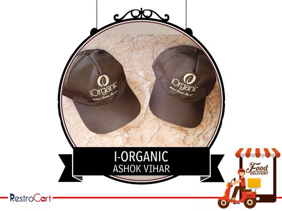 Two dark brown baseball caps with white embroidered logo, on a marble surface, custom made for iOrganic by RestroCart, New Delhi