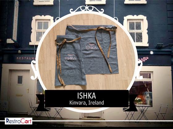 Grey denim waist and bib aprons with tan straps and white printed logo, overlapping, custom made for Ishka Cafe by RestroCart, New Delhi
