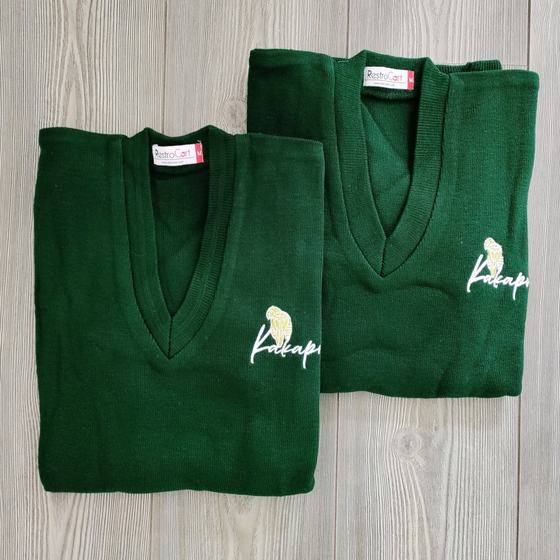 Two bottle green V-neck knit sweaters with white embroidered bird logo, folded, custom made for Kakapo by RestroCart, New Delhi