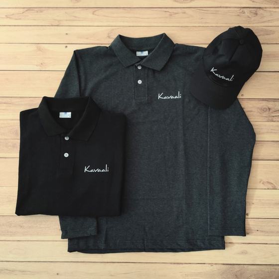 Black and charcoal polo T-shirts with matching black cap, white embroidered script logo, laid flat, custom made for Kavaali by RestroCart, New Delhi