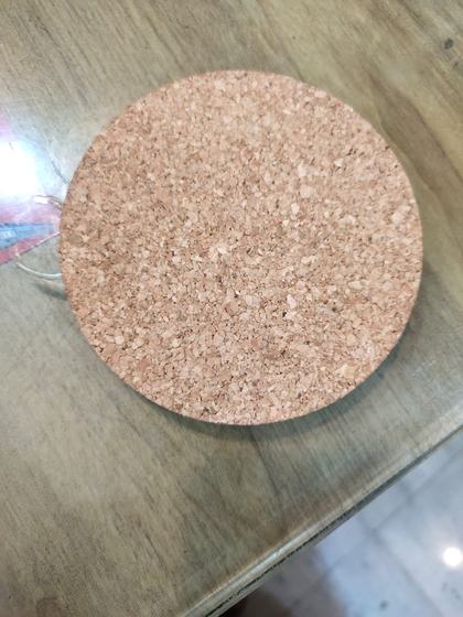 Round natural cork coaster with speckled texture resting on a table top, custom made by RestroCart, New Delhi