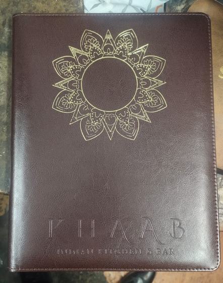 Dark brown leatherette menu cover with gold foil mandala motif and debossed restaurant name, custom made by RestroCart, New Delhi