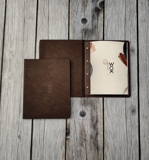 Brown leatherette menu covers with debossed logo, one open on screw posts showing printed menu, custom made by RestroCart, New Delhi