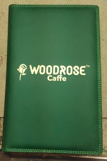 Bottle green stitched leatherette menu cover with large gold foil rose logo and wordmark, custom made by RestroCart, New Delhi